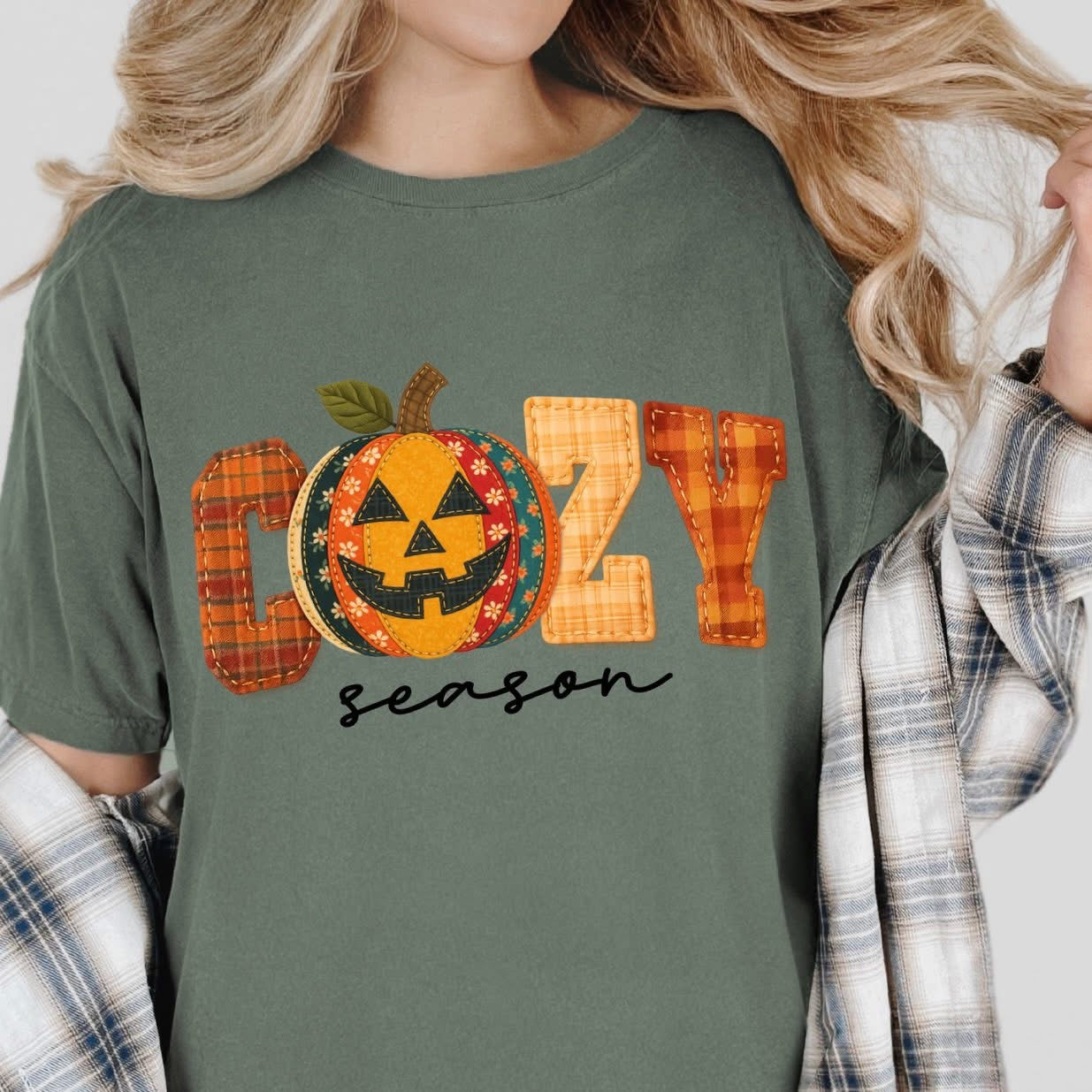 t-shirt with a fall graphic that says βCozy Season,β featuring a plaid patchwork pumpkin jack-oβ-lantern design.