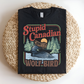 Black t-shirt with 'Stupid Canadian Wolf Bird' graphic design on a woven mat