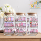 Three glass jars with wooden lids and pink-themed illustrations on a wooden surface.