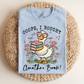 Light blue t-shirt with a cartoon duck holding books and text on a woven mat