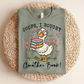 Green t-shirt with a cartoon duck holding books and text on a woven mat